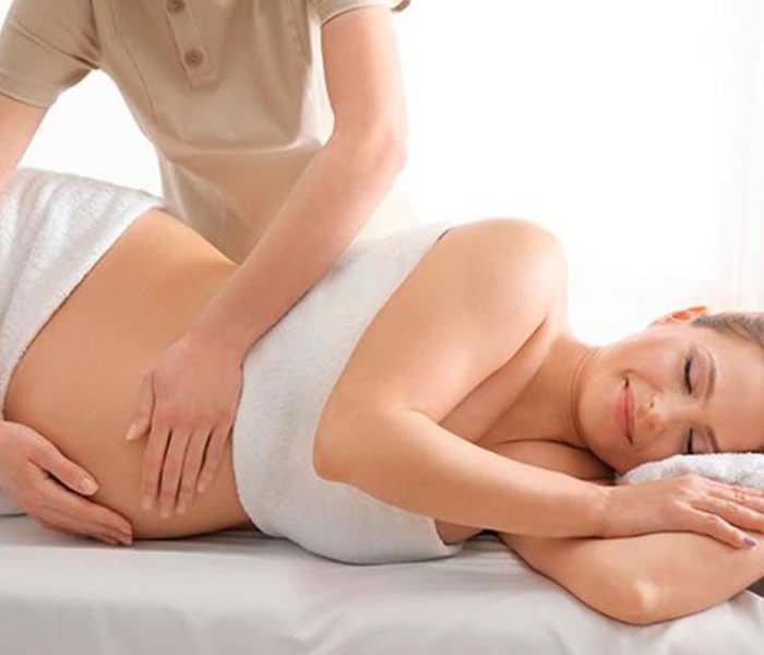 fisioterapeuta dando un masaje a una paciente embarazada