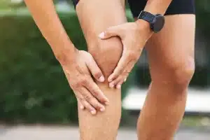 deportista sujetandose la rodilla con las manos