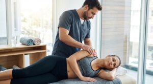 fisioterapeuta tocando hombro paciente